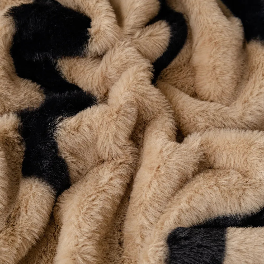 Zebra pattern flannel sofa slipcover in caramel colour, shown draped over a sofa with matching square pillow.