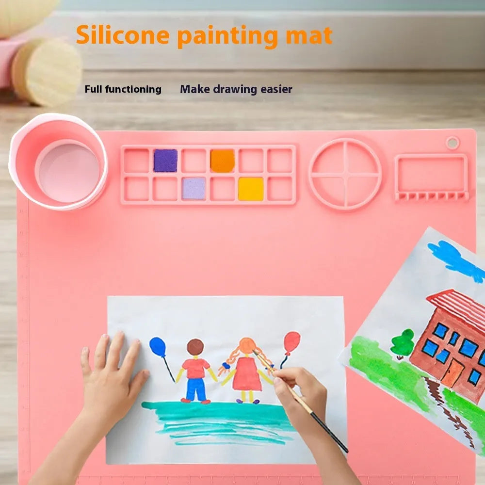 Light blue silicone painting mat with two mixing bowls, measuring 50cm by 40cm on a wooden table.