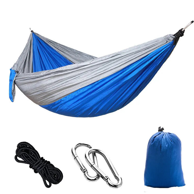Double camping hammock with ropes and buckles shown in outdoor setting