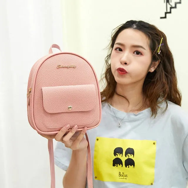 Women's small black PU leather backpack shoulder bag showing front zipper and dimensions