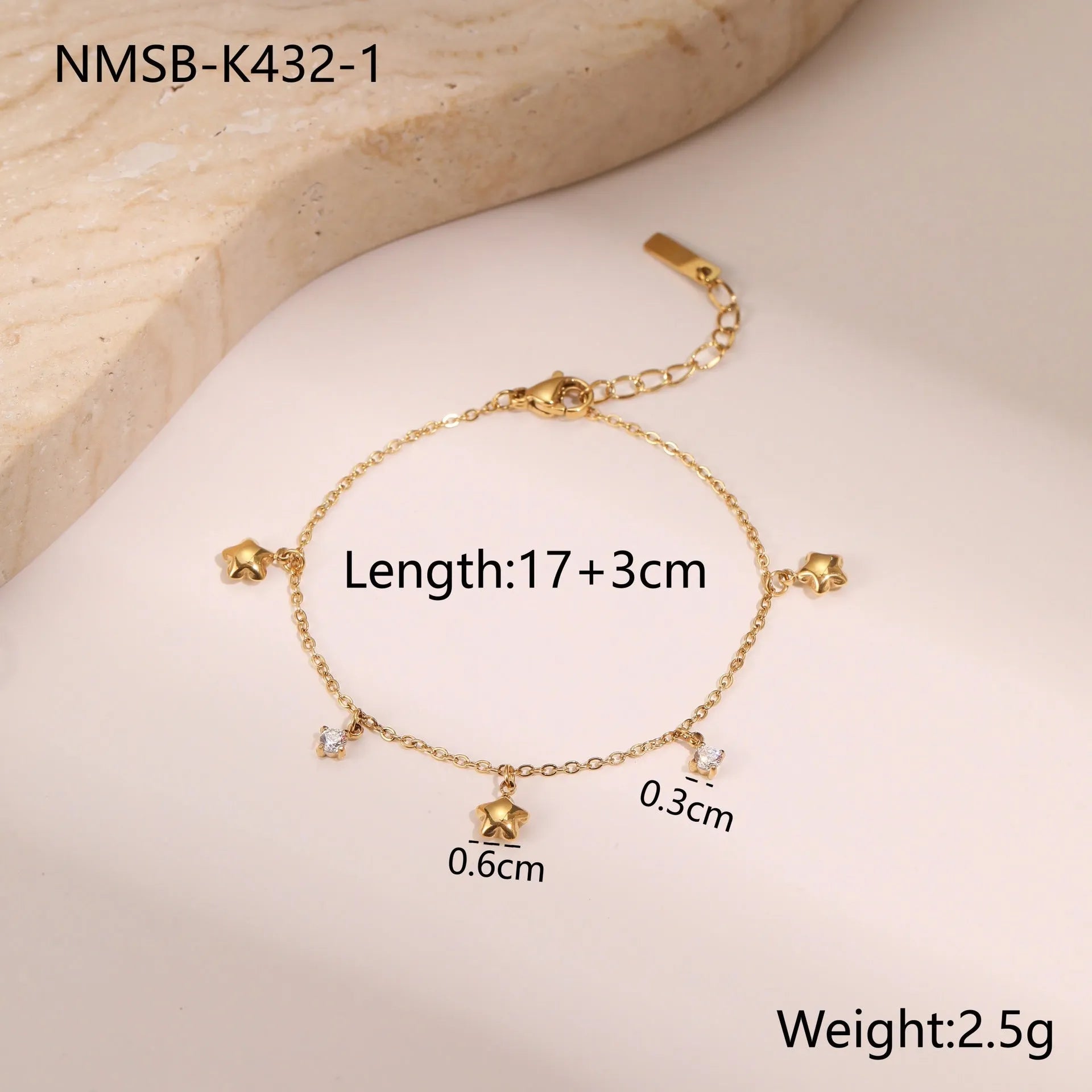 Gold plated stainless steel bracelet with a detailed zircon star pendant on a woman's wrist.