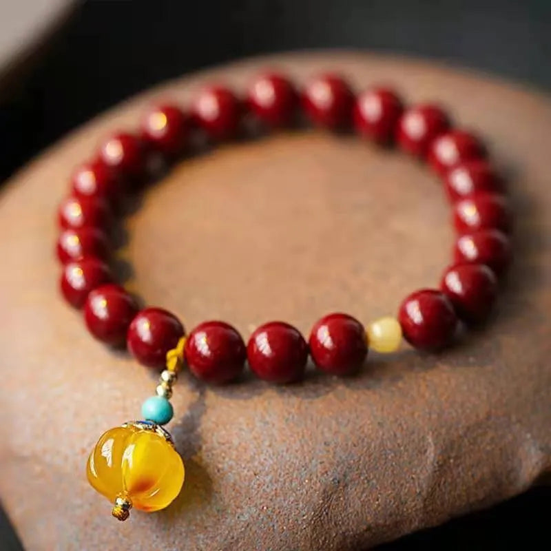 Gold cinnabar and copper wave bracelet in pumpkin or brand colour on wrist.