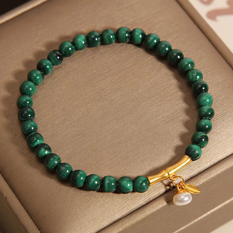 Close-up of a women's white crystal bracelet with a raised lucky bamboo design on the wrist.
