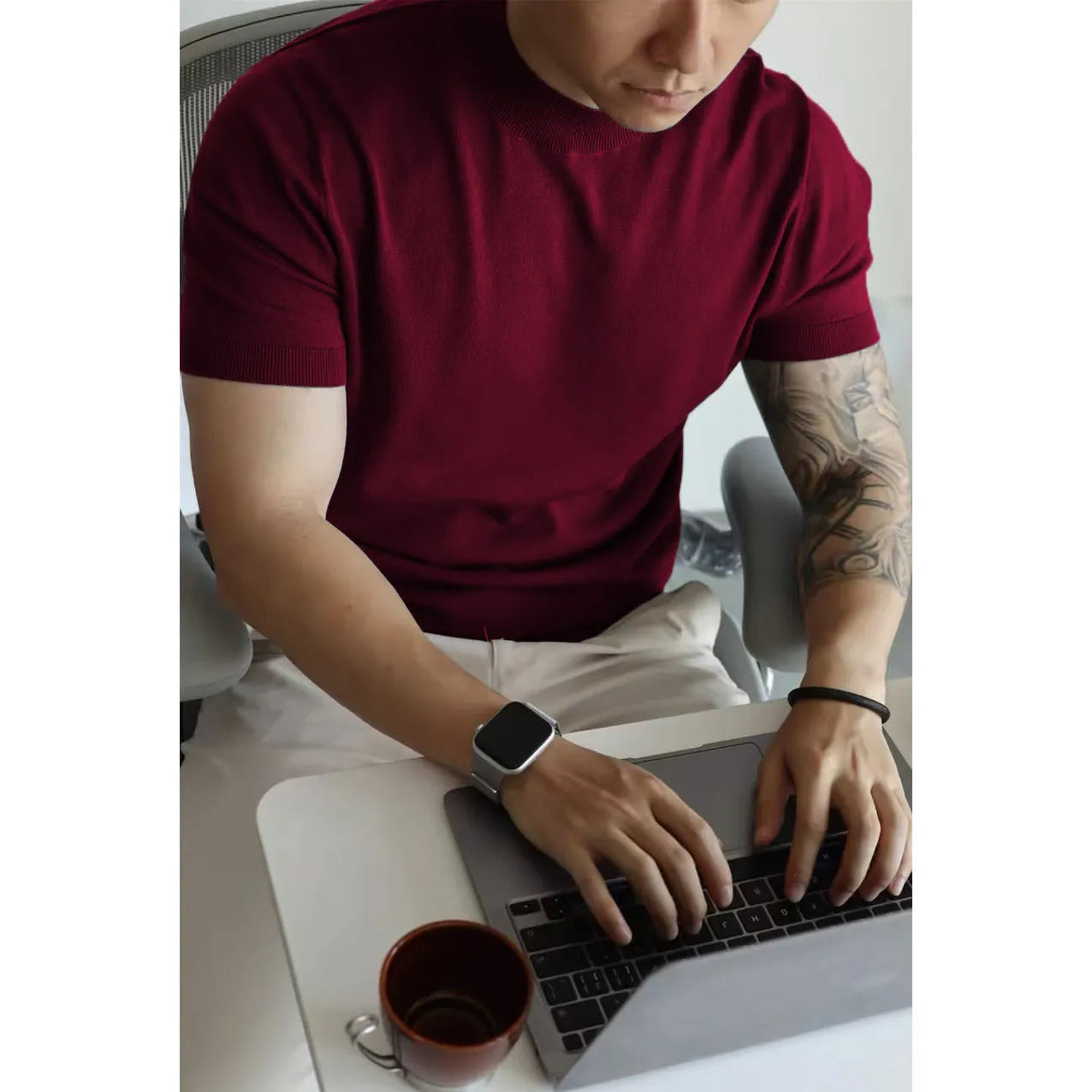 Man wearing a slim-fit solid colour polyester t-shirt, showcasing its lightweight knitwear construction.