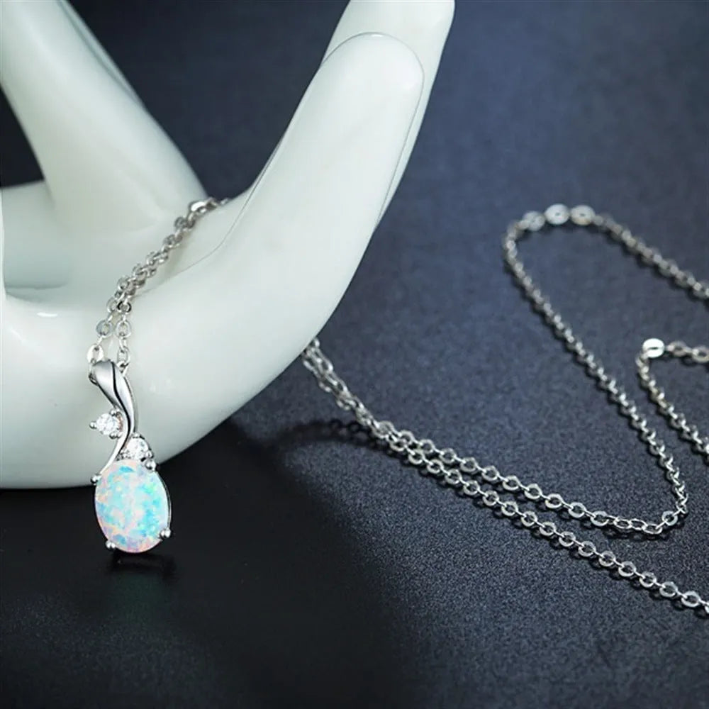 Close-up of a water drop shaped opal pendant on an adjustable O-link chain, shown in a rose gold finish.