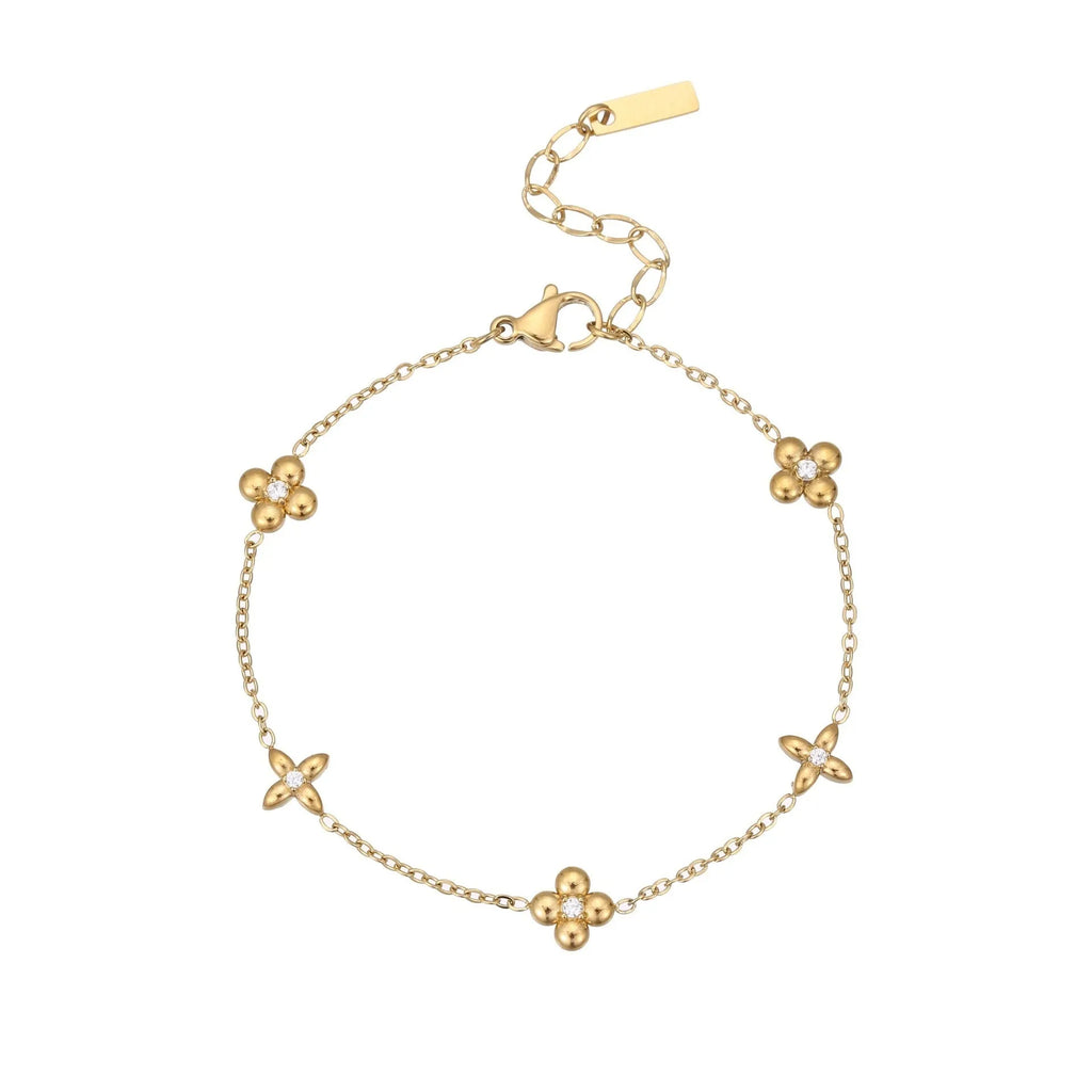 Gold plated stainless steel bracelet with a detailed zircon star pendant on a woman's wrist.