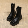 Black women's platform Martin ankle boots with a square toe, high heel, and back zipper on a white background.