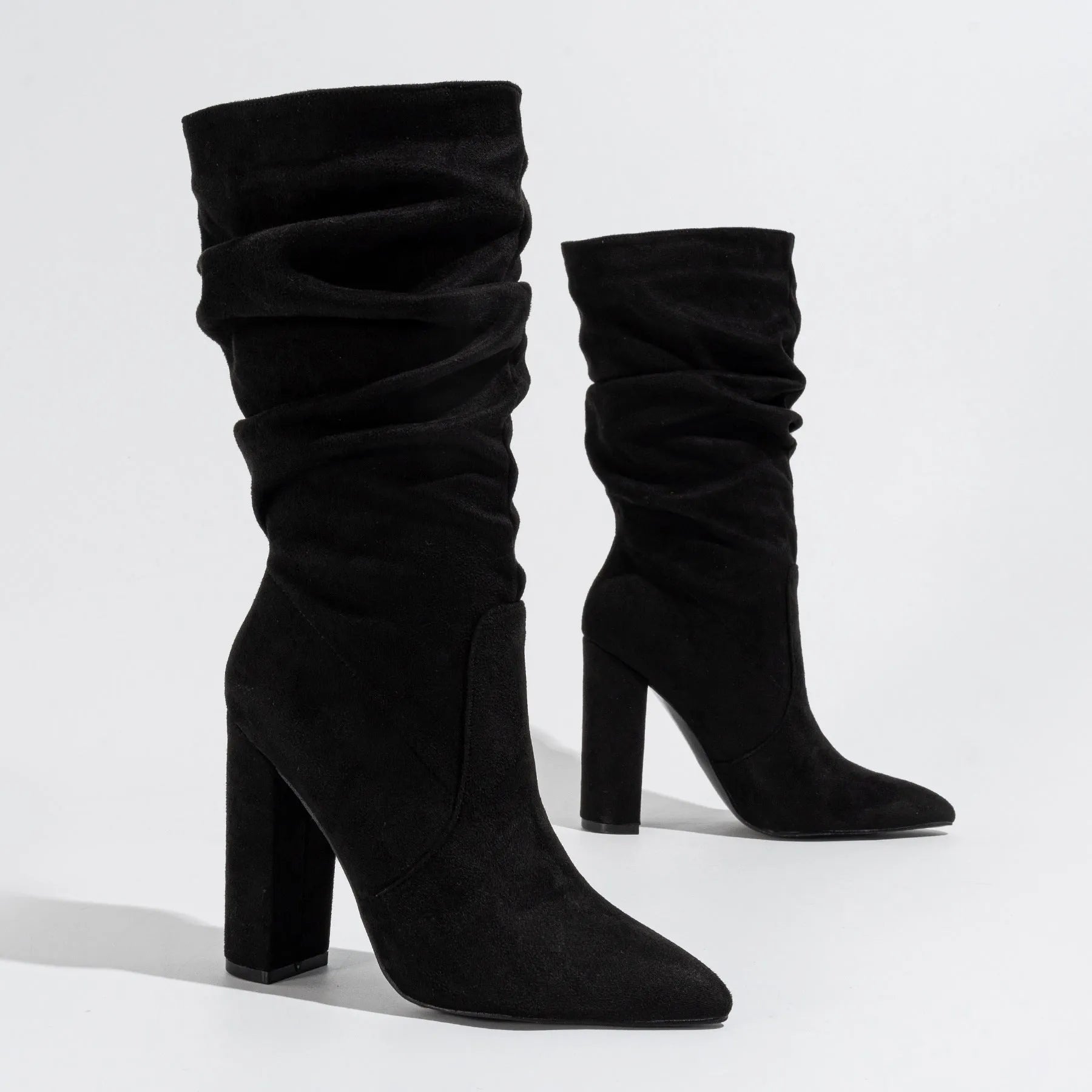 Women's black suede chunky heel pointed-toe boots with a high heel above 8cm and calf-length socks.