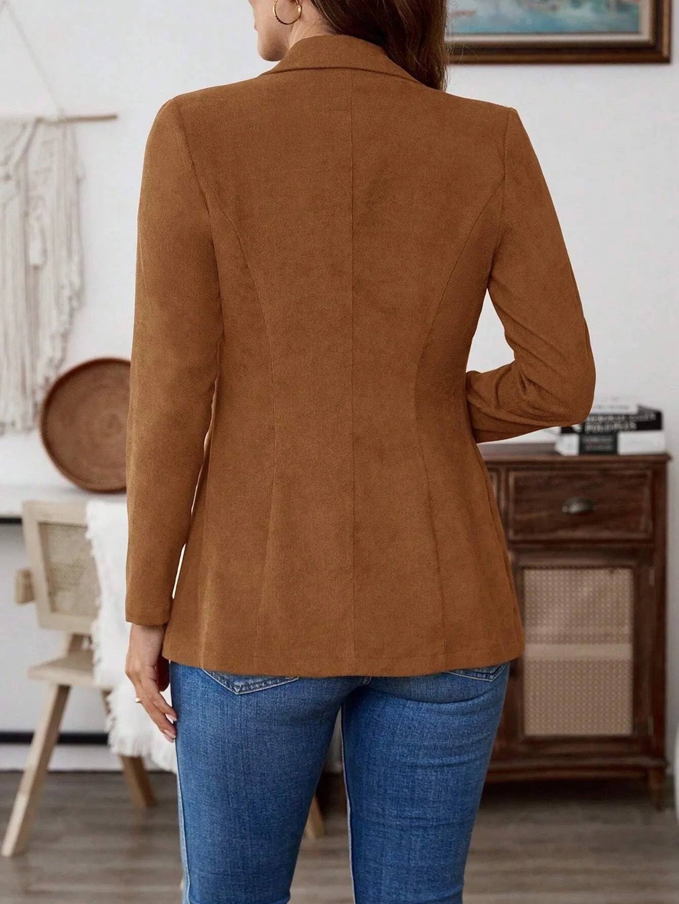 Brown men's single-breasted suit coat with lapels and long sleeves on a hanger