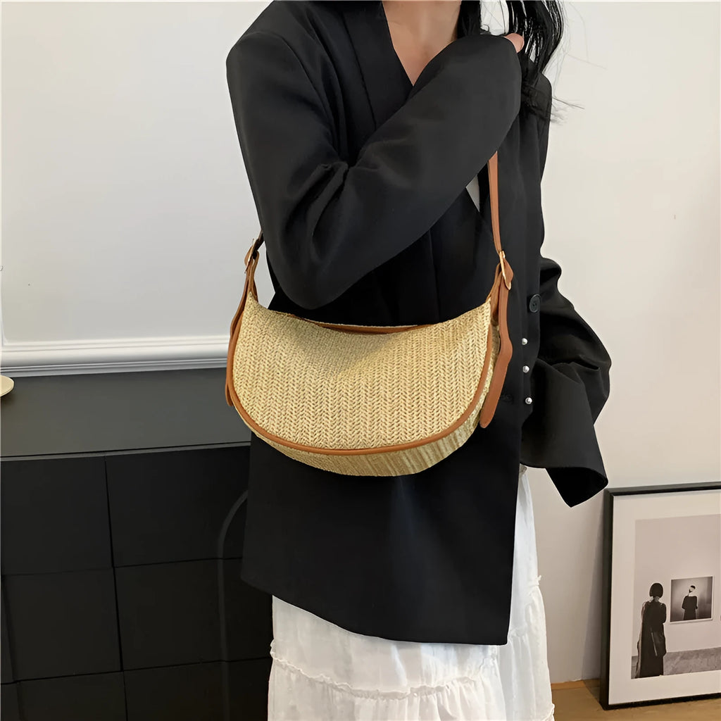 Women's straw woven crossbody bag showing woven texture and internal phone and document compartments