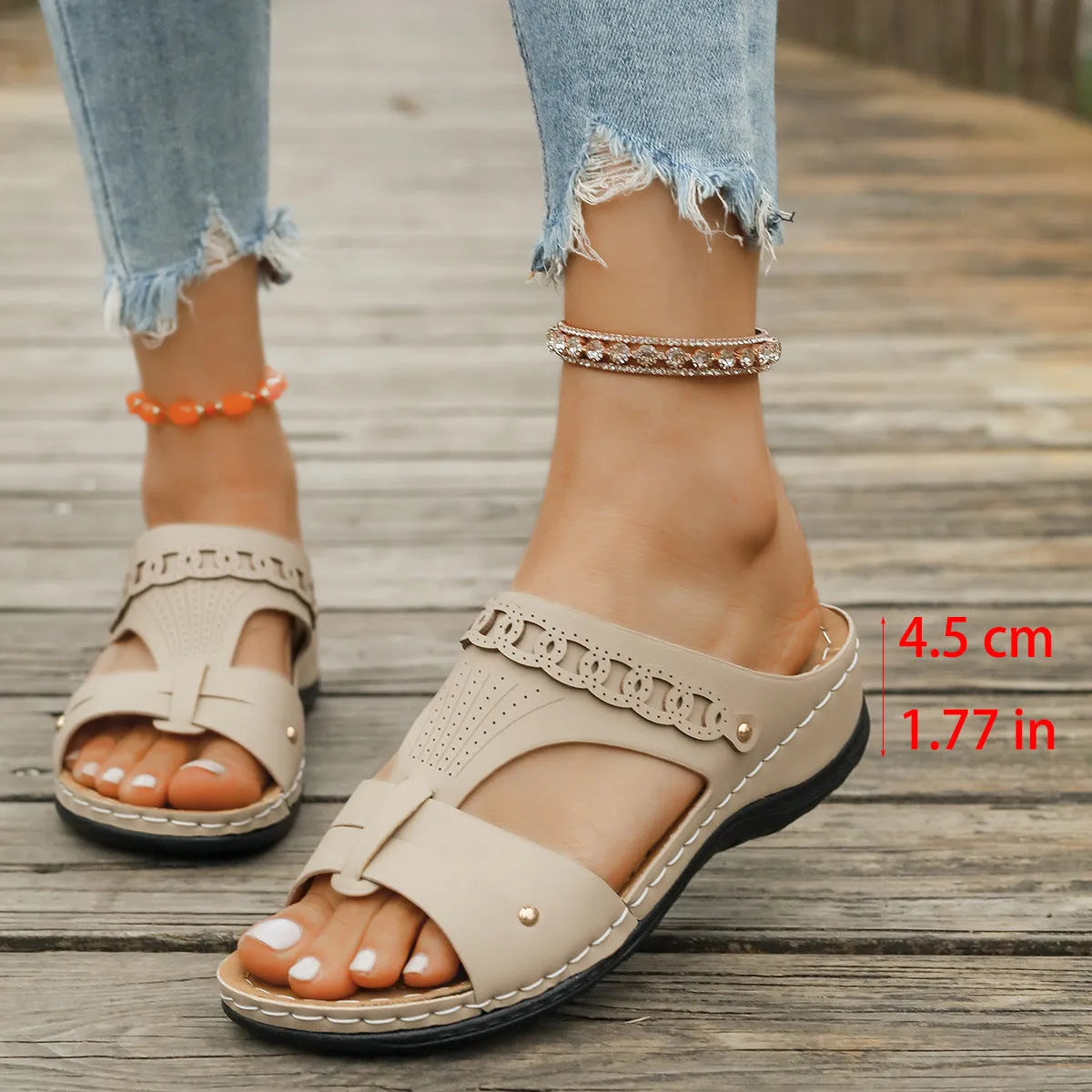 A pair of beige Roman-style slope heel slippers with a fish mouth toe holder on a plain background.