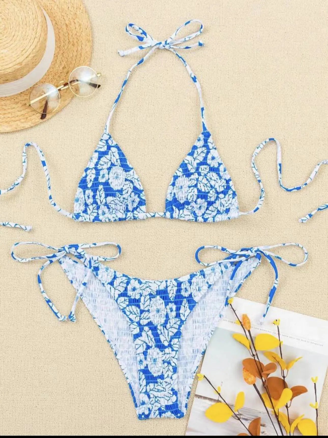 Women's floral print halter neck swimsuit briefs in light blue on a mannequin.