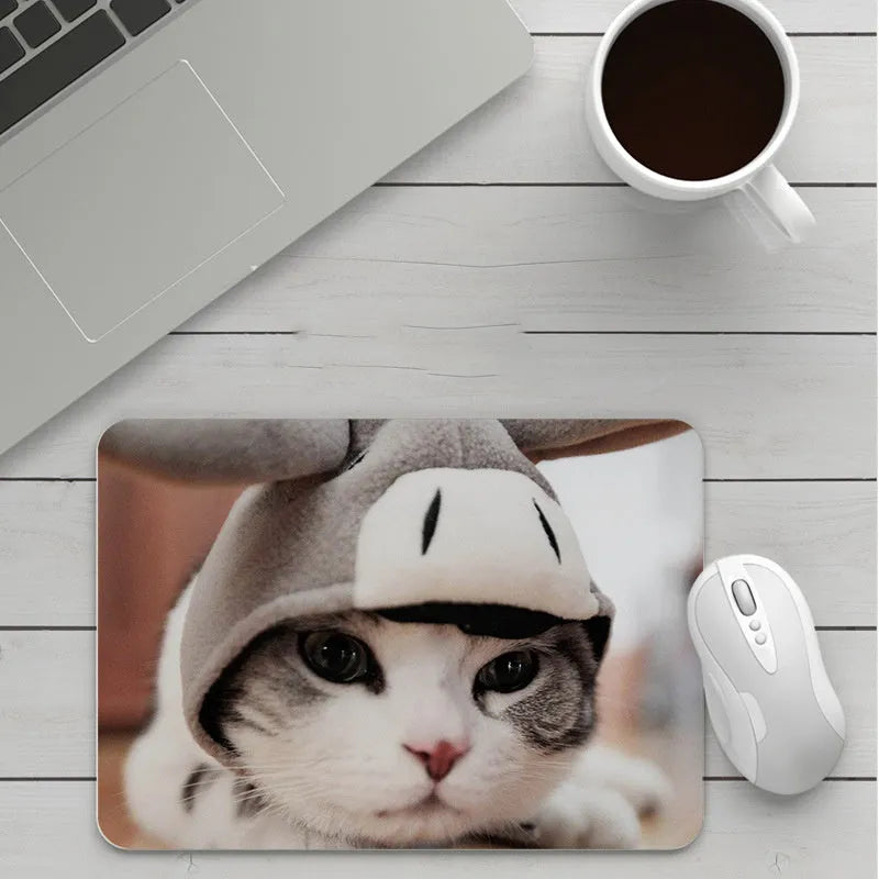 Custom cartoon design on a small black thickened mouse pad with stitching, shown on a desk.