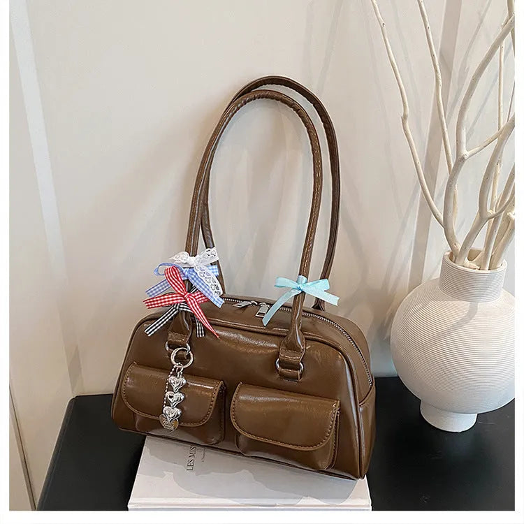 Retro one-shoulder pillow handbag in PU leather, shown in black with a flap closure and double straps.