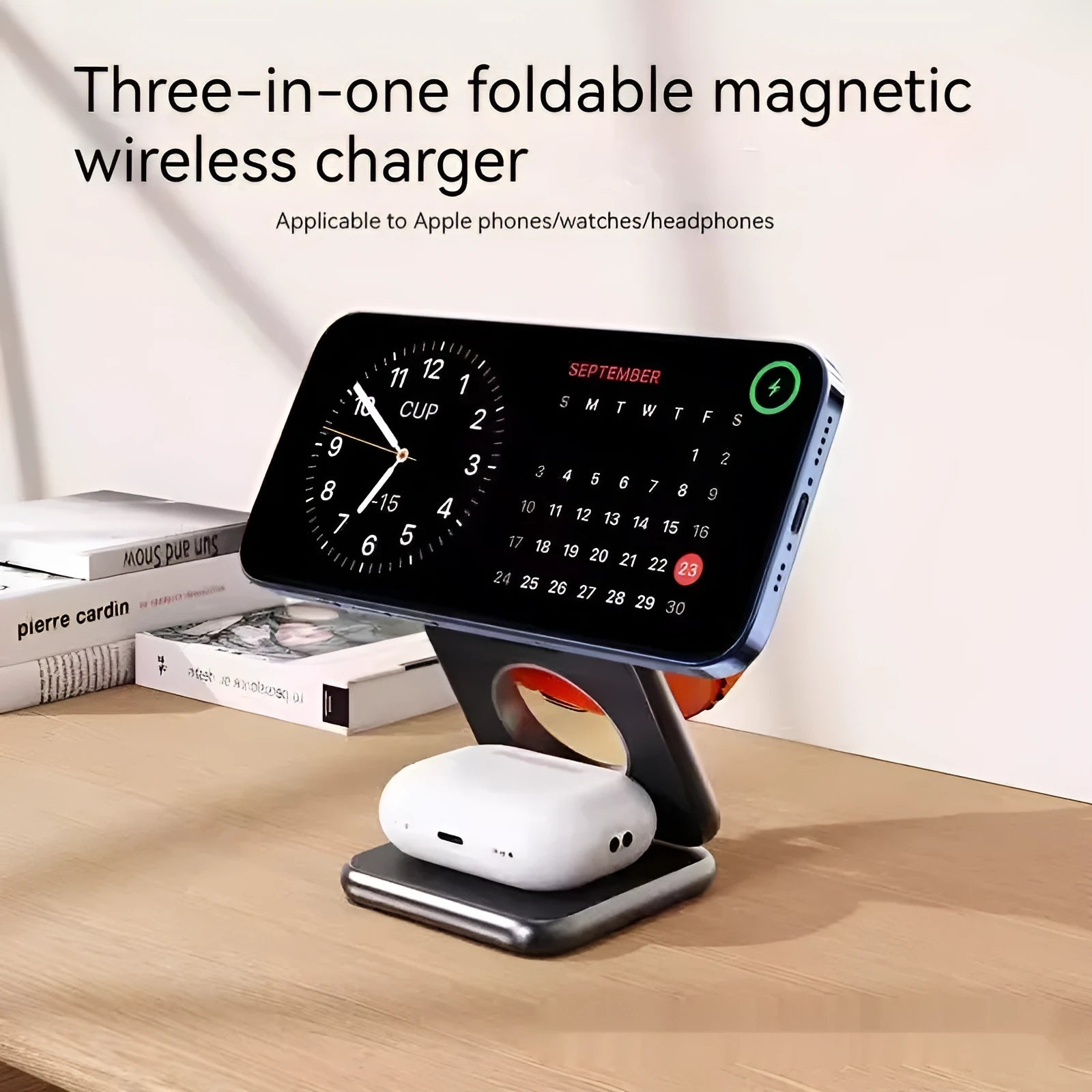White foldable magnetic wireless charging phone stand on a wooden desk next to a mobile phone.