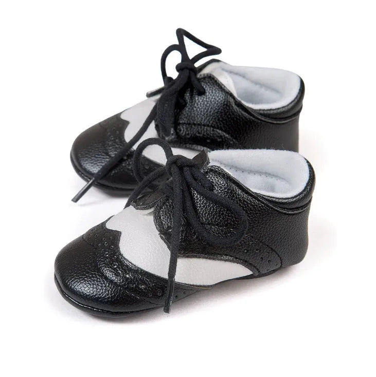 Vintage style soft-soled baby shoes for boys in synthetic leather, available in black, grey, light brown, and white.