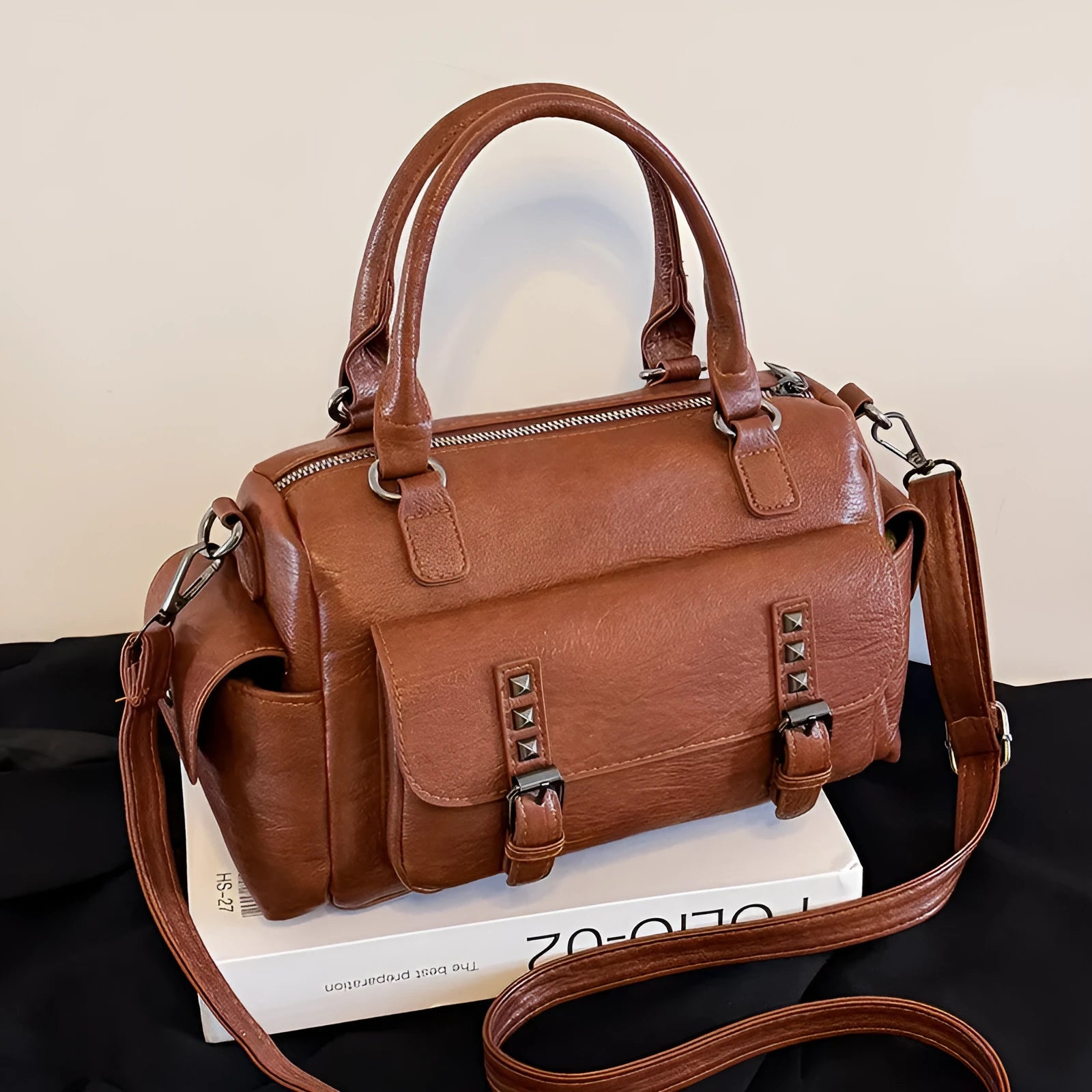 Vintage messenger bag in horizontal square shape showing stitching details and shoulder strap