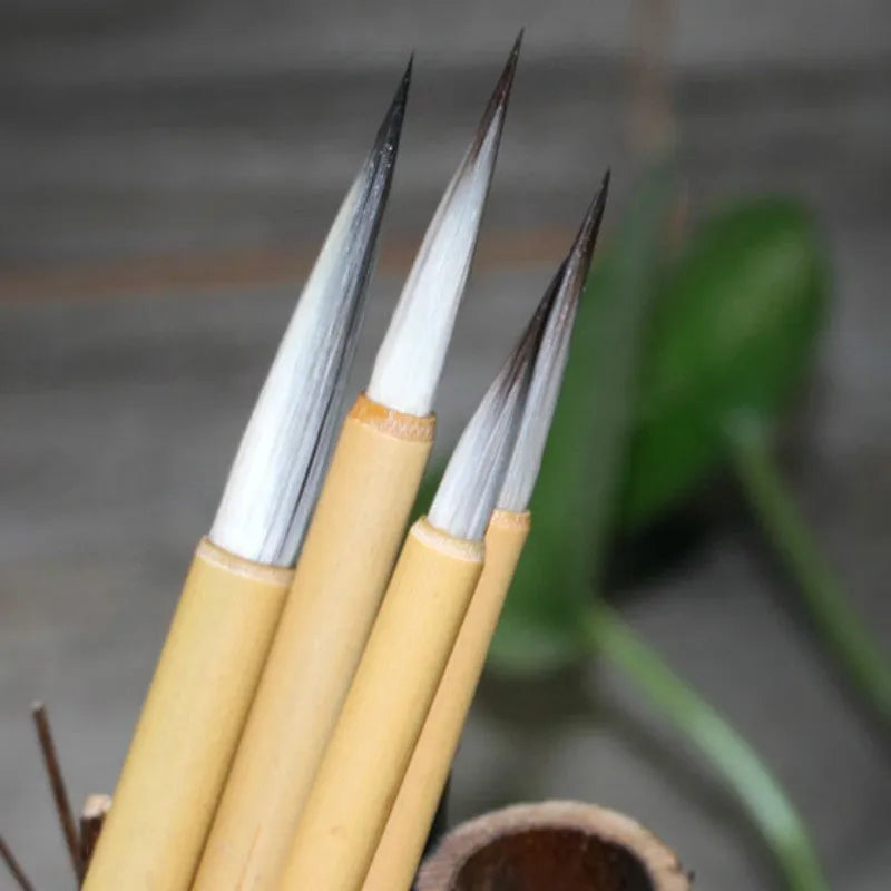 Four fine lower case writing brushes with thin gold body and mixed hair bristles in pine branch colour