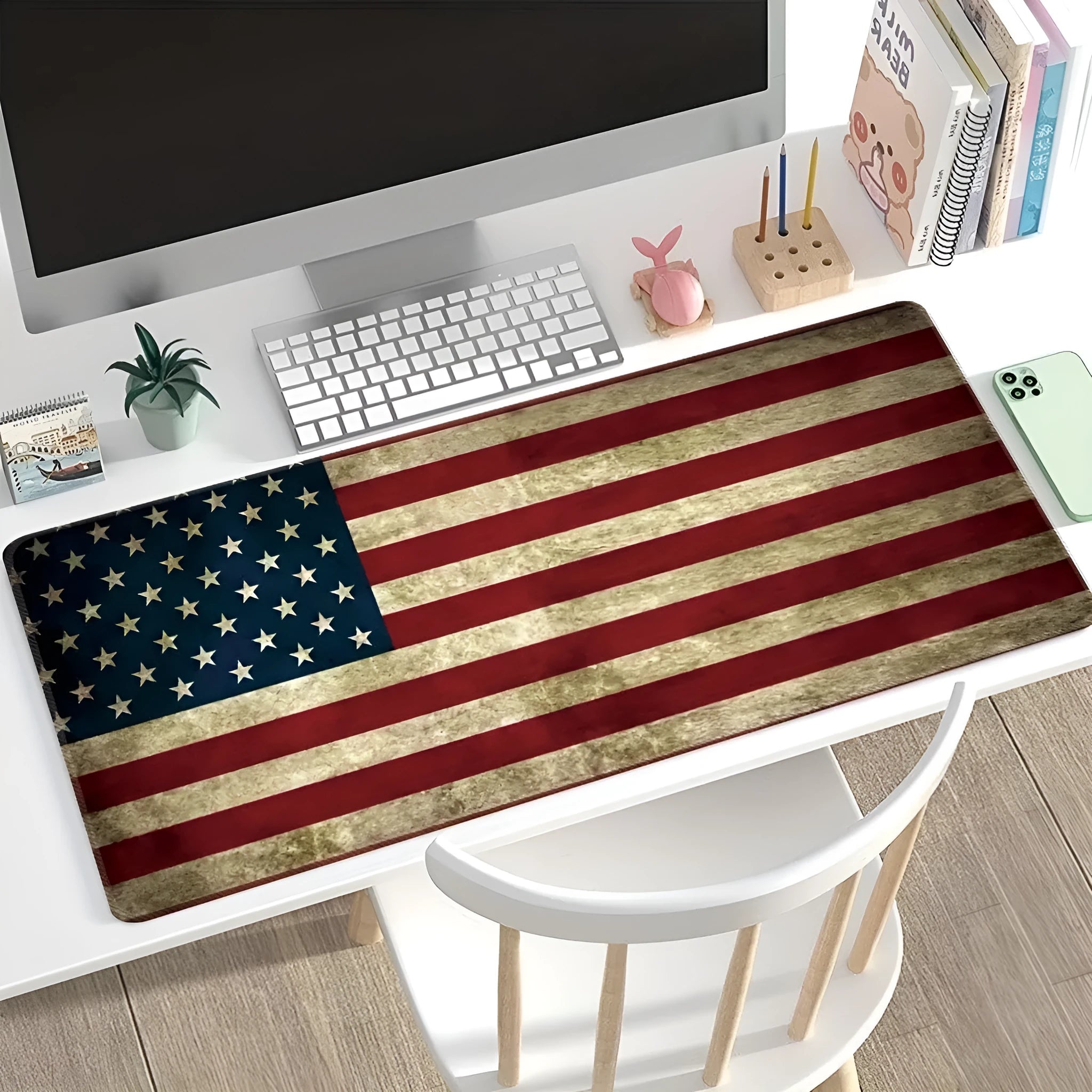 Large black rubber desk mouse pad with a printed geometric pattern, shown on a wooden desk.