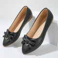 Women's beige flat casual slip-on shoes with a bowknot and shallow mouth design on a white background.