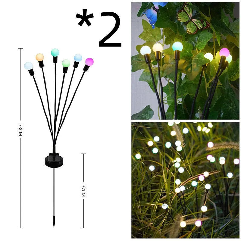 Solar-powered LED firefly lawn light with ground stake inserted in grass