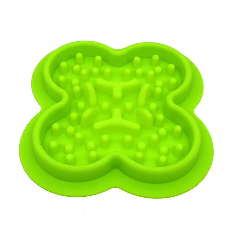 Silicone pet slow feeder licking mat with raised edges in assorted colours on a kitchen floor.