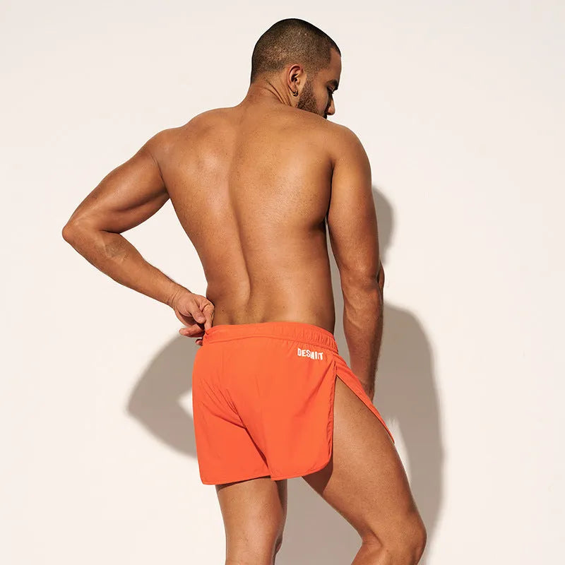 Men's loose-fit polyester surfing trousers in black, fluorescent green, and orange red colours