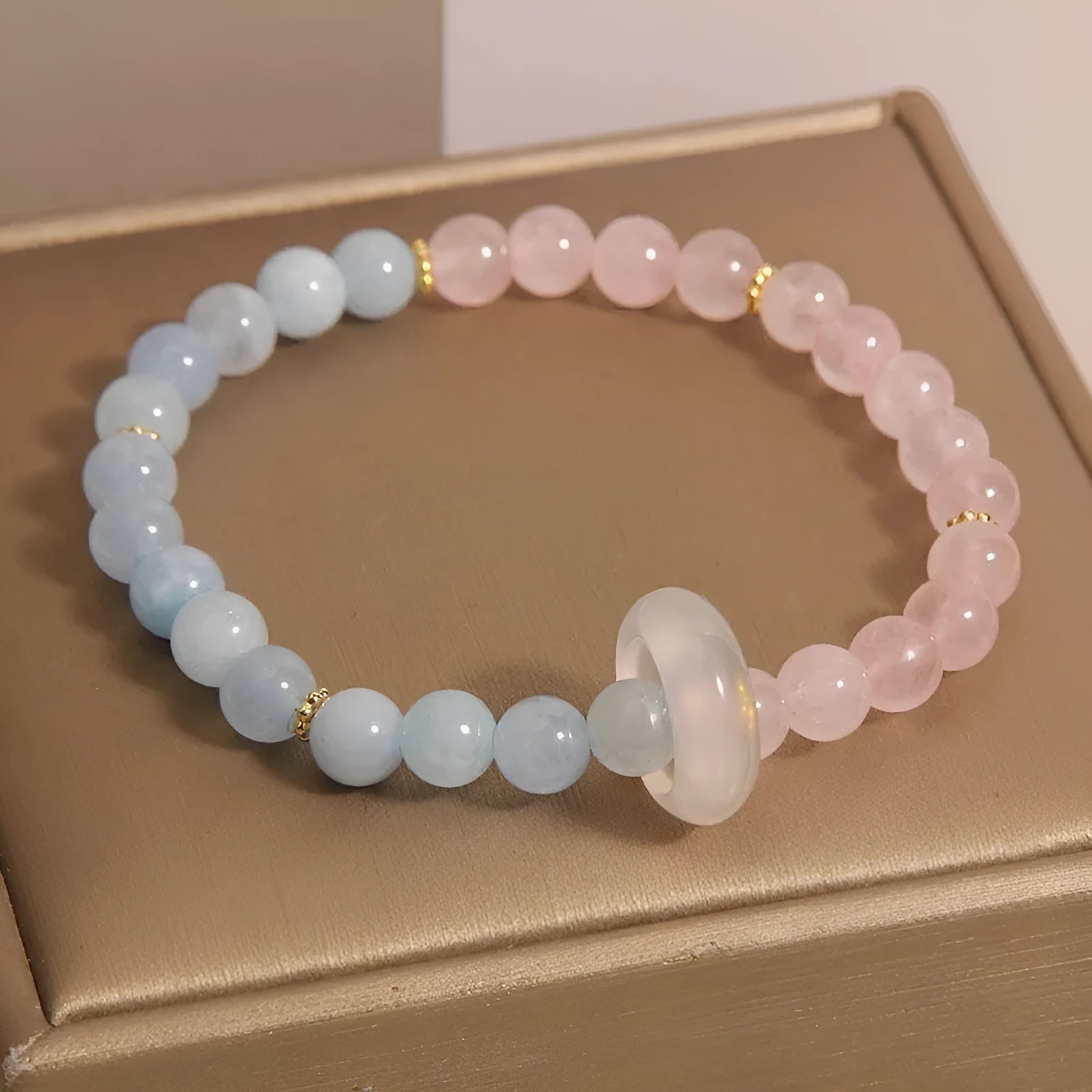 Aquamarine crystal bracelet with mixed materials including pink beads, white pearls, and peach blossom elements