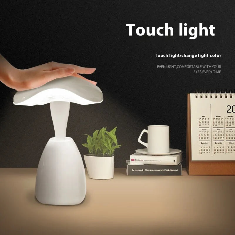White modern plastic LED desk lamp with touch control on a wooden surface.