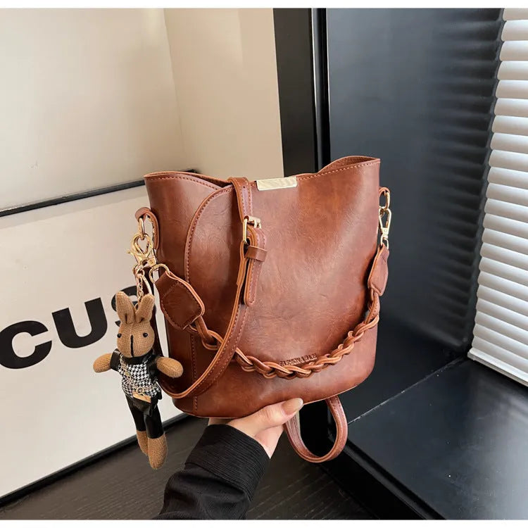 Women's retro bucket messenger bag in PU leather, 21x11x21 cm, with pendant detail and double shoulder strap connector