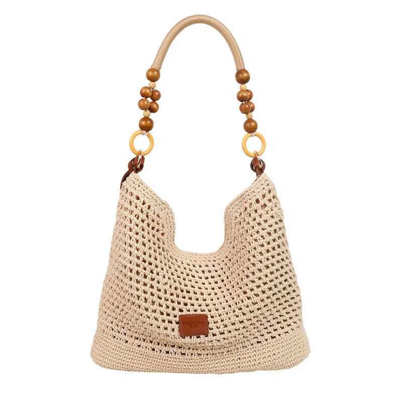 Knitted tote beach bag in bucket shape with crossbody strap showing contrast stitching details