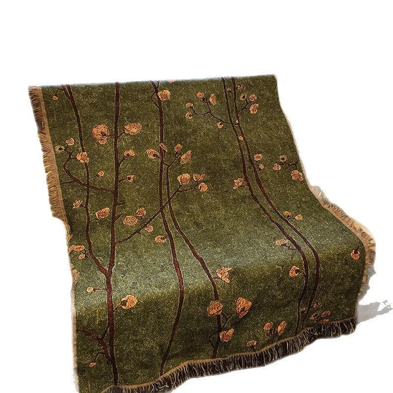 Chinese retro green plum blossom woven polyester sofa cover 130x160cm with tassels on a sofa