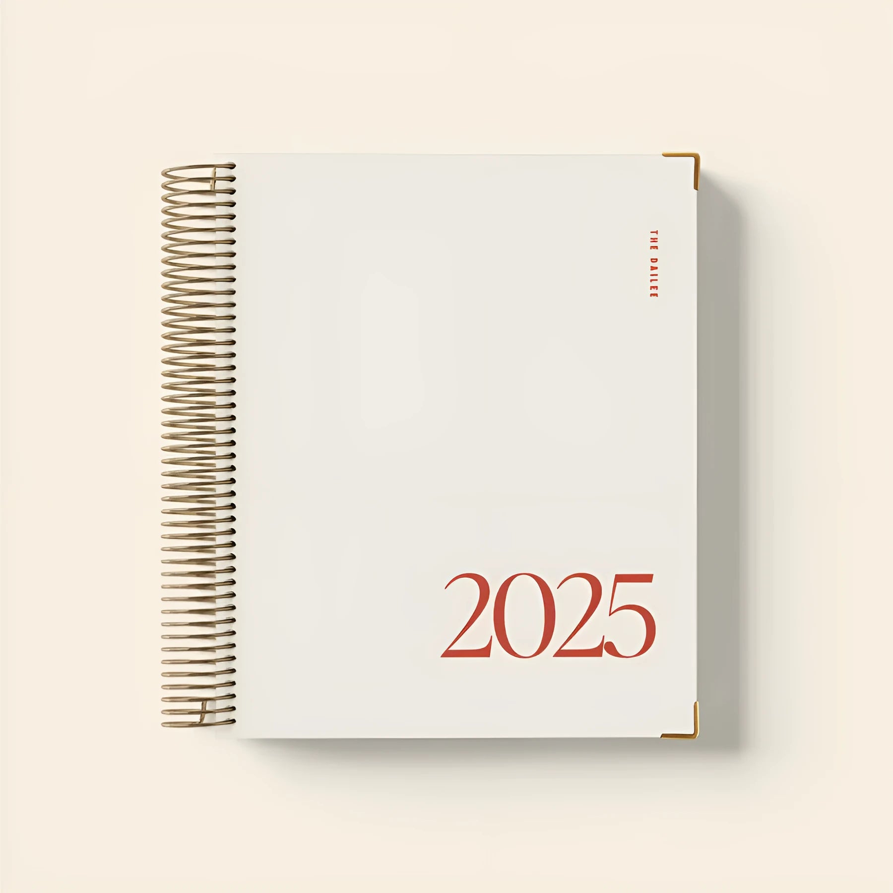 Cherry red coil notebook open on a desk, showing spiral binding and paper pages for scheduling.