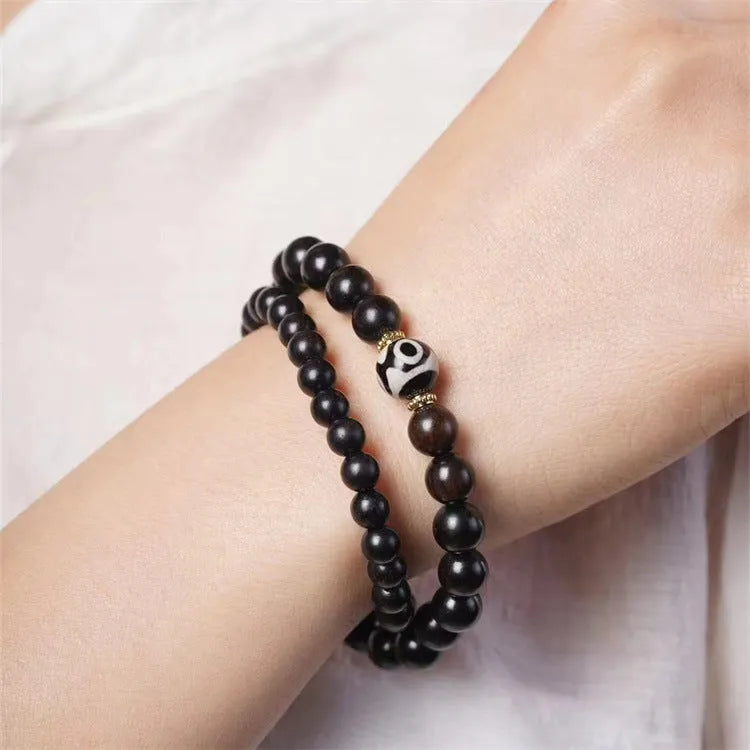Solid ebony wood bracelet with 8mm Tibetan beads showing two-circle pattern