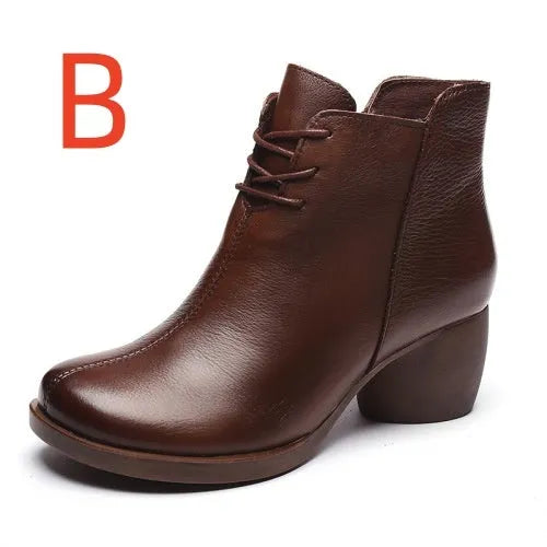 Brown women's leather Martin boots with a thick round heel and round toe on a wooden floor.