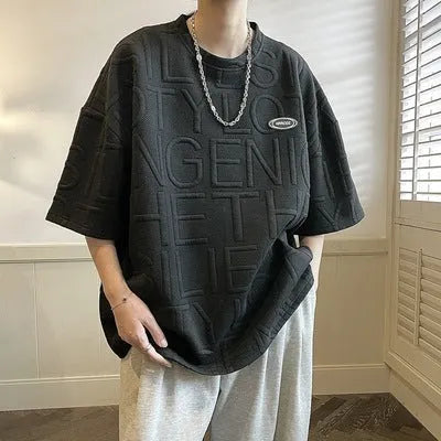 Men's grey loose-fit T-shirt with a raised white three-dimensional letter print on the chest.