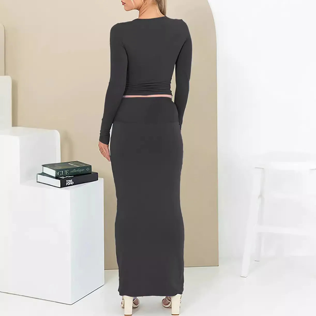 Women's black polyester two-piece suit with waist-exposing top and long skirt