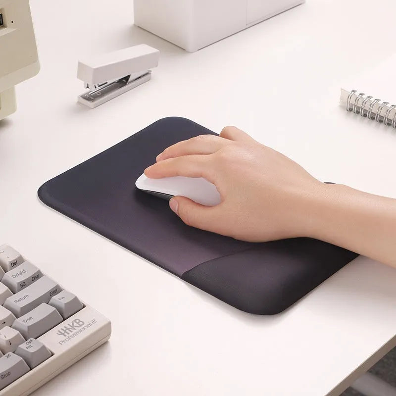 Square silicone wrist rest mouse pad with wrist strap in multiple colour options on a desk