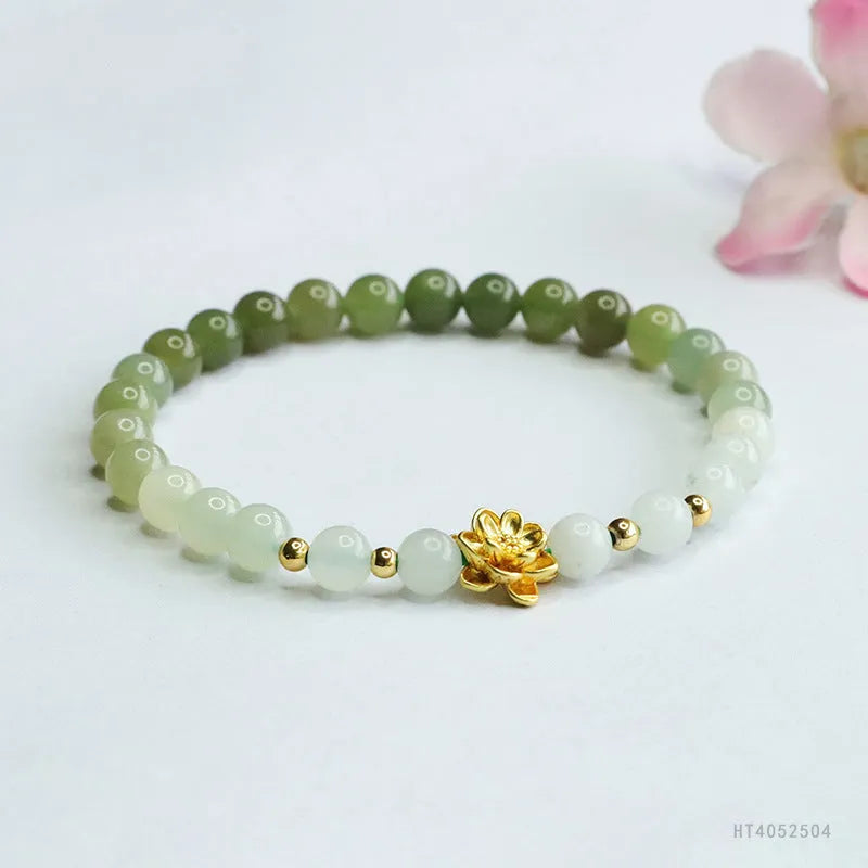 Hand-woven clear water gradient Hetian jade bracelet with flower-shaped beads on a white background.