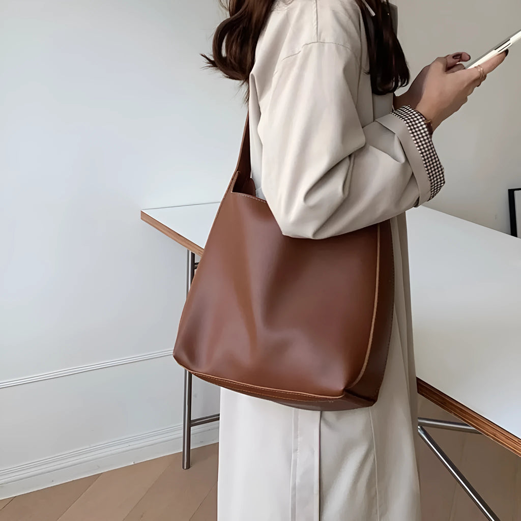 Women's soft PU leather shoulder bag with swing threads in black and brown colours showing ribbon and pocket detailing