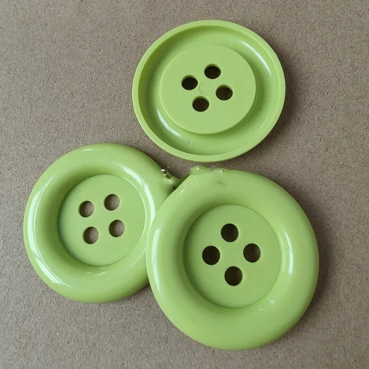 Oversized round plastic sewing buttons in multiple colours with four holes