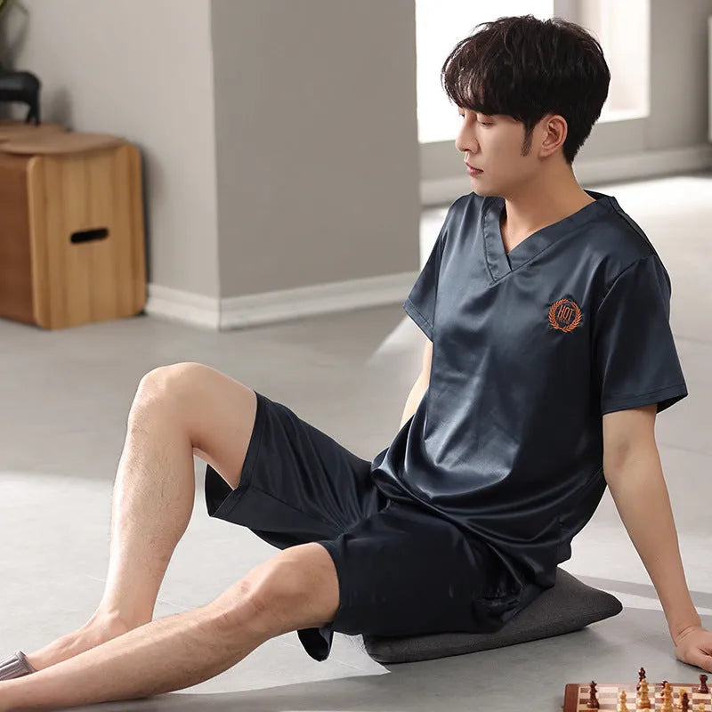 Man wearing a light grey ice silk short-sleeve pajama shirt and matching loose shorts.