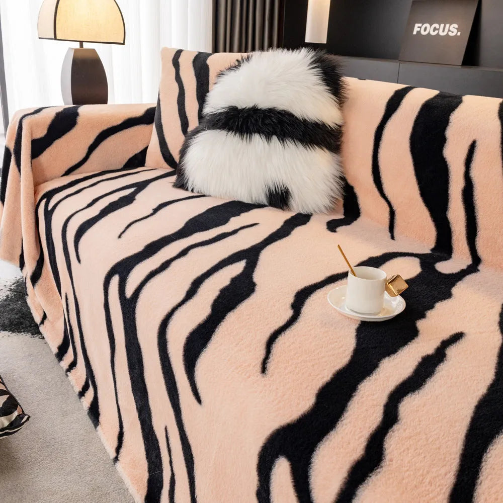 Zebra pattern flannel sofa slipcover in caramel colour, shown draped over a sofa with matching square pillow.