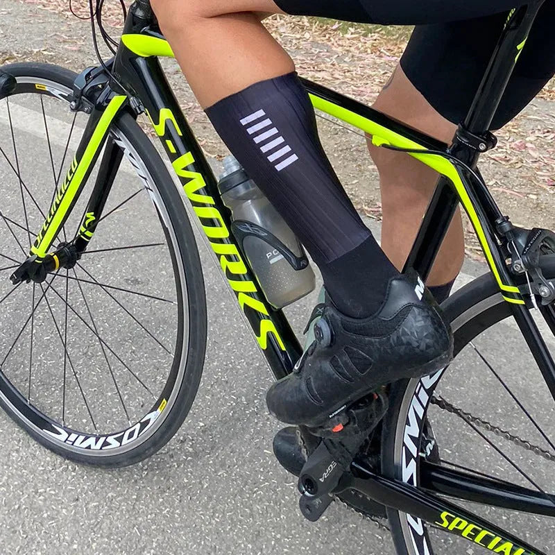 Pair of breathable chemical fibre blend athletic socks for cycling and running, shown in orange colour.