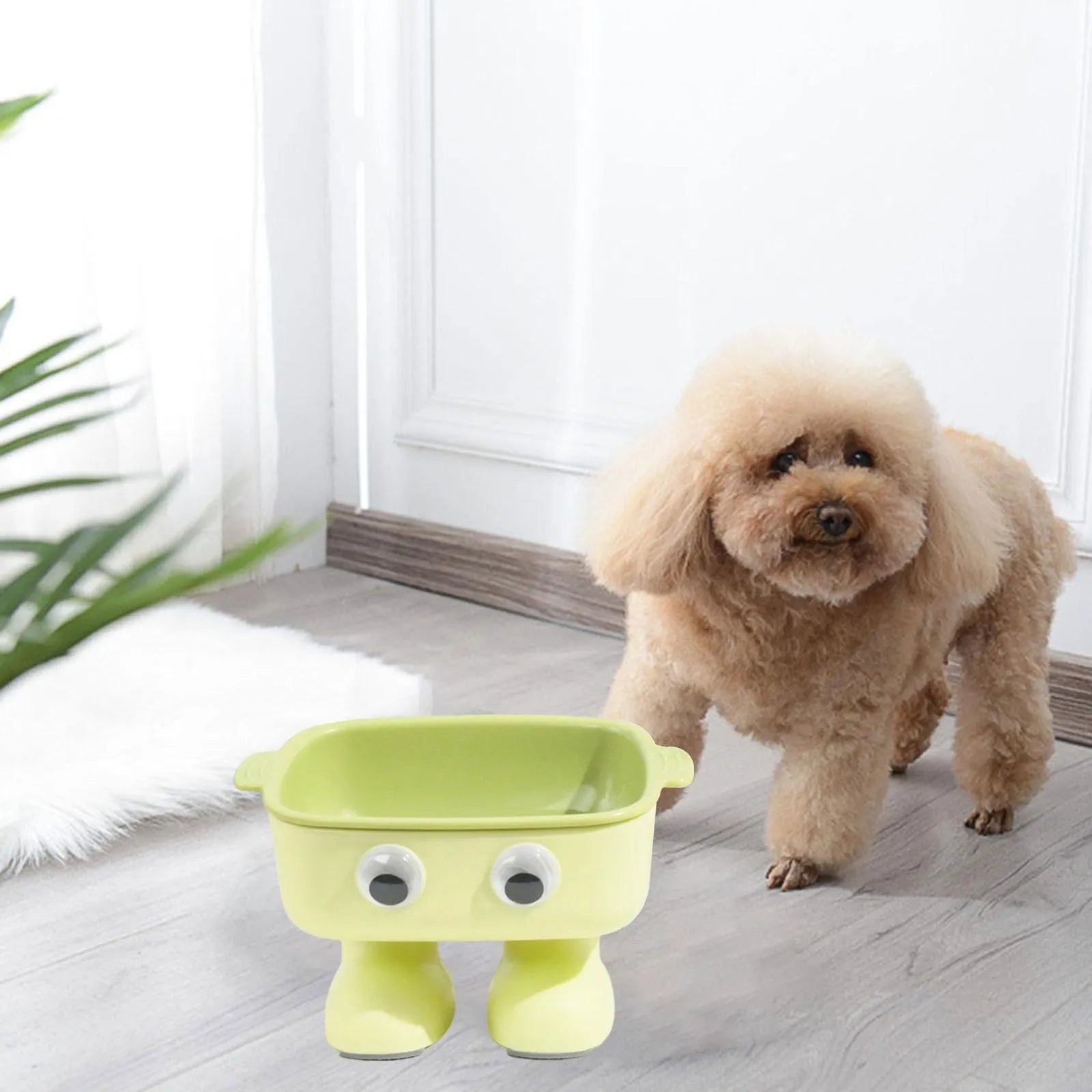 Green robot-shaped elevated cat bowl with tilted food dish and non-slip base.