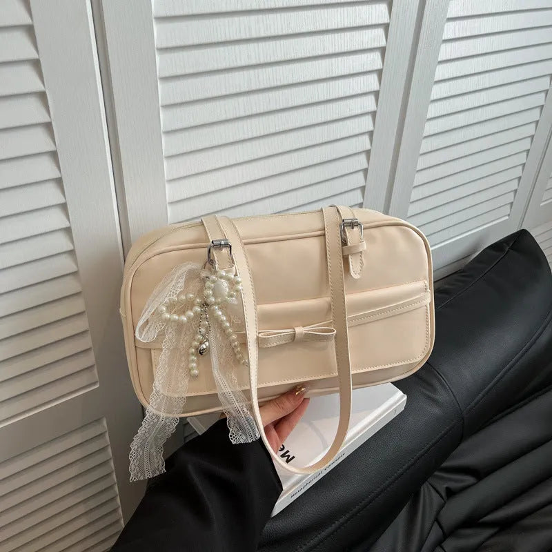 Single-shoulder flap bag in horizontal square shape with bow decoration and internal phone compartment