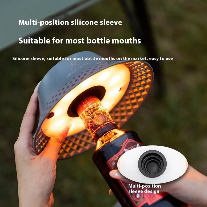 Beige wine bottle shaped camping lantern with USB-C port shown on a table.