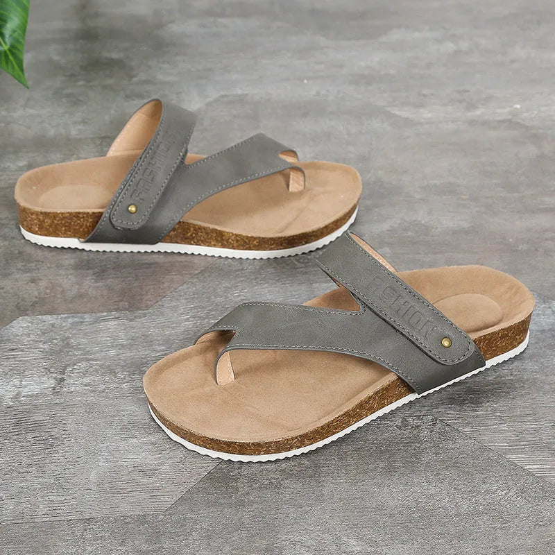 Thick-soled blue flip-flops with flat toe ring design on beach background