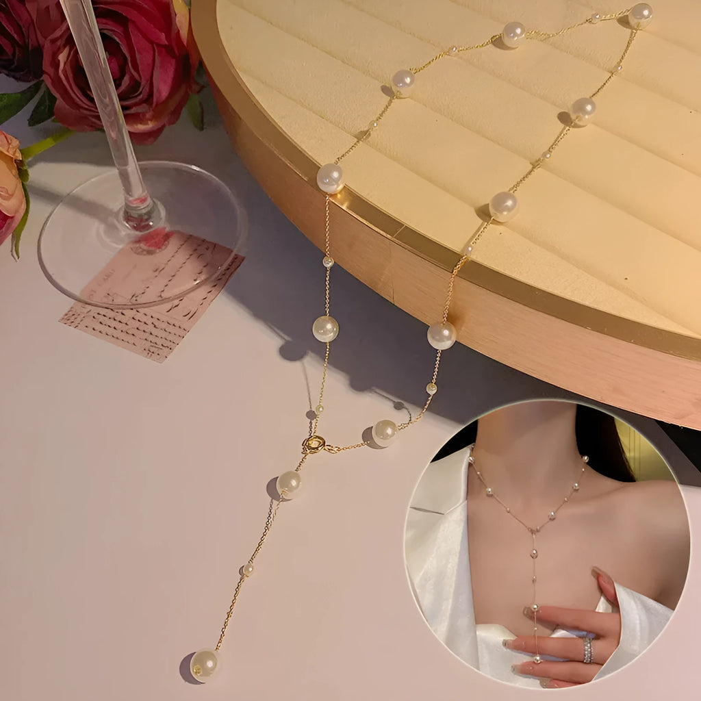 Gold starry pearl choker necklace on a white surface showing imitation pearl chain