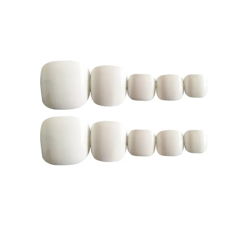 Set of white press-on fake nails with a starry sky pattern and a bottle of nail glue.